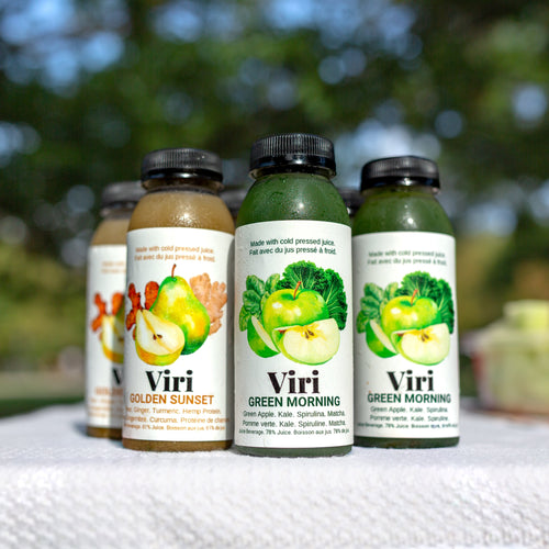 Four bottles of Viri juice beverages with colourful labels on a white surface outdoors.